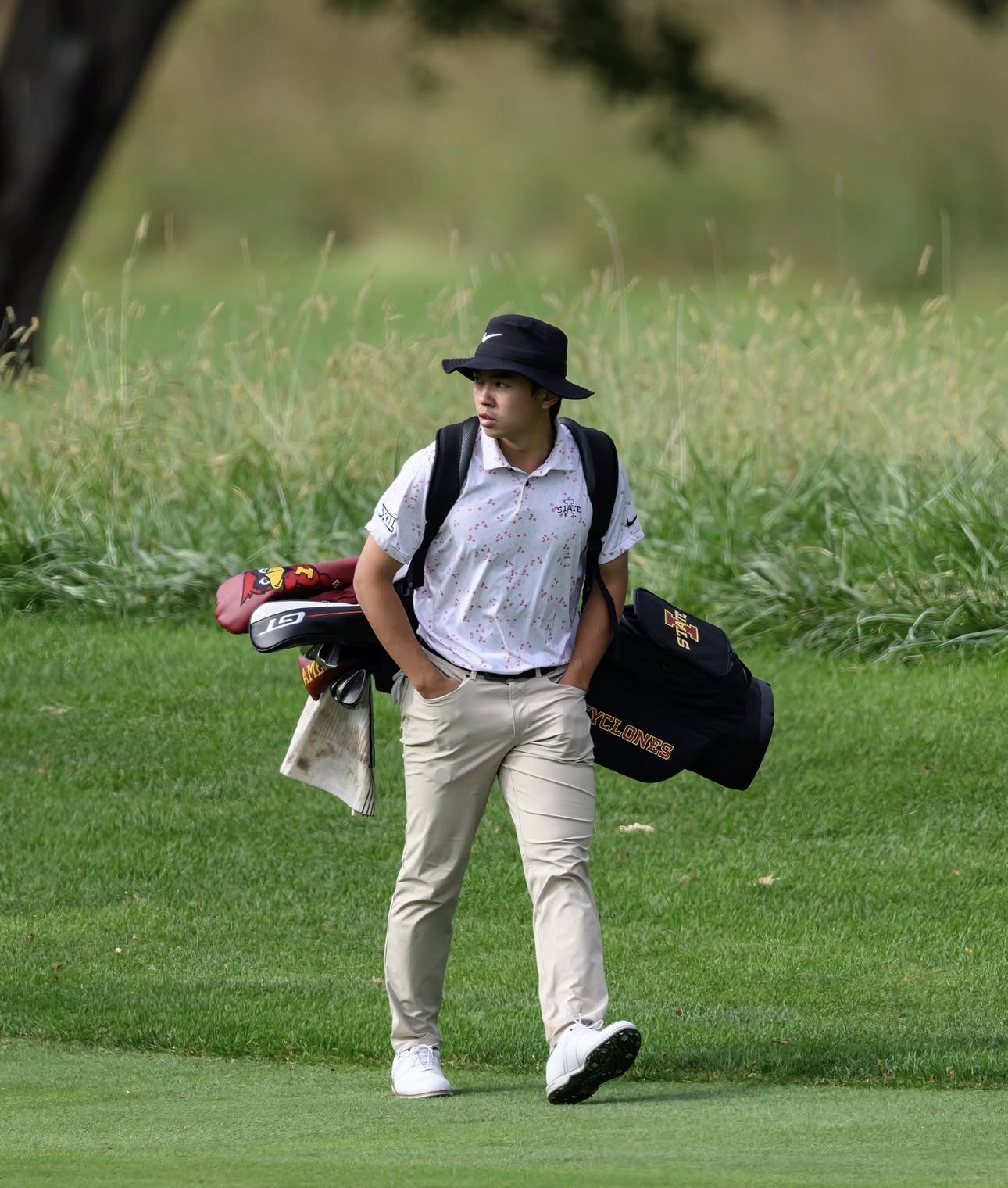 Dianchao Wu walking on the course with his Iowa State golf bag